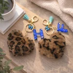Personalized brown plush heart keychain with blue acrylic initial for backpack