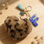 Personalized brown plush heart keychain with blue acrylic initial for backpack