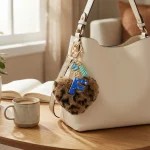 Personalized brown plush heart keychain with blue acrylic initial for backpack