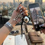Vintage braided keychain with antique silver charms and star mirror, black and white paracord bag charm.