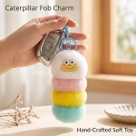 Close-up of fluffy worm monster keychain showing hand-stitched smiley face and soft faux fur texture.