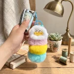 Close-up of fluffy worm monster keychain showing hand-stitched smiley face and soft faux fur texture.