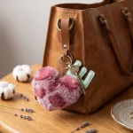Close-up of the initial letter keychain showing stitched PU leather letter and leopard faux fur heart.