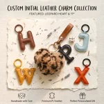 Close-up of the leather initial keychain showing leopard faux fur heart and stitched genuine leather letter.
