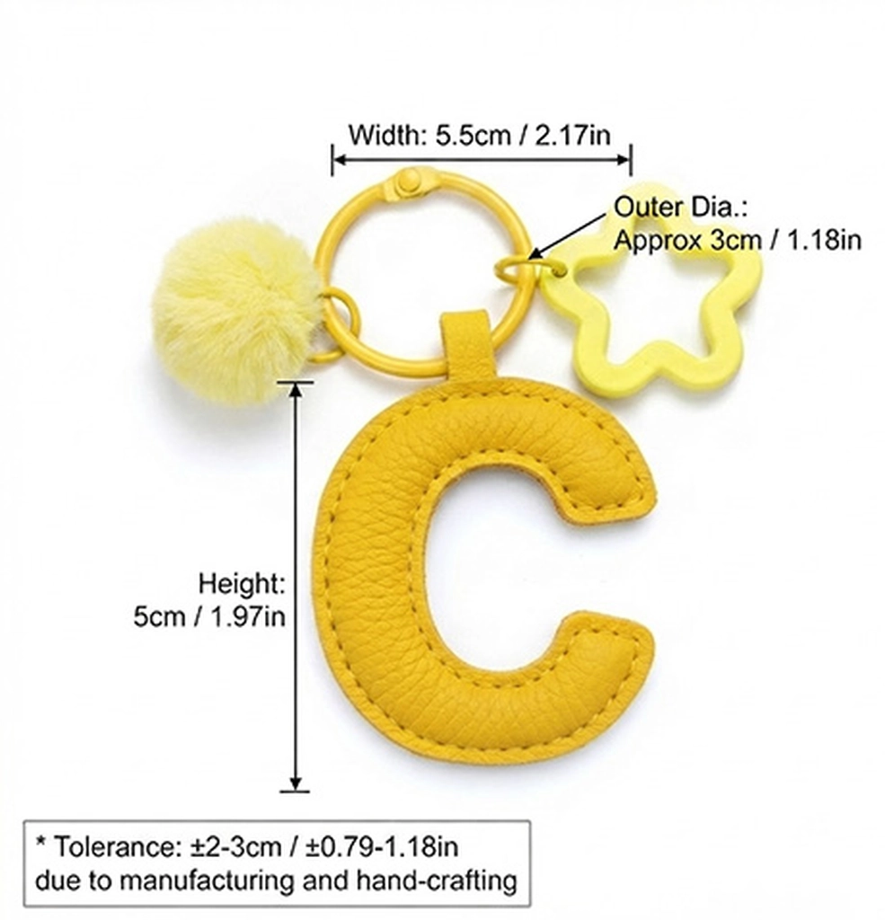 Close-up of the Letter C keychain showing padded sunny yellow PU leather and soft faux fur pom pom.