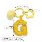 Close-up of the Letter G keychain showing padded gentle yellow PU leather and soft faux fur pom pom.