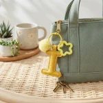 Close-up of the Letter I keychain showing padded sunshine yellow PU leather and soft faux fur pom pom.