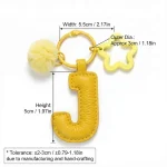 Close-up of the Letter J keychain showing padded jelly yellow PU leather and soft faux fur pom pom.