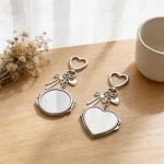 Open folding compact mirror inside the silver heart mirror keychain showing clear HD glass.