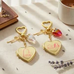 8 color variations of gold heart locket keychain with cute strawberry charms.