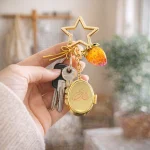 Personalized star locket keychain with custom golden retriever photo and cute strawberry charm.
