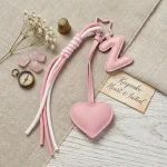 Personalized initial heart keychain in pink PU leather with 26 letters cutout.
